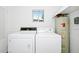 Functional laundry room with washer, dryer, water heater, and a window for ventilation and natural light at 1408 Watts Ave, Orlando, FL 32809