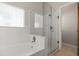 Bright bathroom featuring white tiles, a shower with glass doors, and a soaking tub at 1415 Hensley Dr, Deland, FL 32724