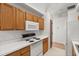 Well-lit kitchen offers wood cabinets and white appliances at 1415 Hensley Dr, Deland, FL 32724