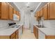 Galley kitchen featuring wooden cabinets, white appliances and white countertops at 1415 Hensley Dr, Deland, FL 32724