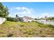 An overgrown backyard featuring fence and partial view of screened-in pool at 145 Henue Ct, Davenport, FL 33896