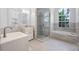 Bright bathroom with tub, glass shower, double sink, and tiled floor at 145 Henue Ct, Davenport, FL 33896