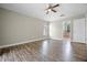 Spacious bedroom with wood-look flooring, ceiling fan, and access to the ensuite bathroom at 145 Henue Ct, Davenport, FL 33896