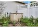 A view of the home equipment in an overgrown landscape with fence at 145 Henue Ct, Davenport, FL 33896