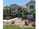 Charming single-story home featuring mature palm trees and a well-maintained, colorful stone garden at 145 Henue Ct, Davenport, FL 33896