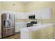 Bright kitchen featuring stainless steel appliances, white cabinets, and a convenient breakfast bar at 145 Henue Ct, Davenport, FL 33896