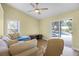 Cozy living room with vaulted ceiling, ceiling fan, wood flooring, and sliding glass doors to pool at 145 Henue Ct, Davenport, FL 33896