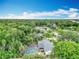 An aerial view shows the neighborhood with lush tree coverage and the home's screened in pool at 148 Tarrytown Trl, Longwood, FL 32750