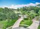 Aerial view showcasing the home, driveway, lush landscaping, and partial view of the adjacent golf course at 148 Tarrytown Trl, Longwood, FL 32750