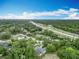 An aerial view shows a neighborhood with a highway nearby, all surrounded by lush tree coverage at 148 Tarrytown Trl, Longwood, FL 32750