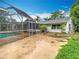 Lush backyard with a view of the home and a screened-in pool at 148 Tarrytown Trl, Longwood, FL 32750