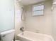 Bright bathroom featuring a shower-tub combination, a window, and tiled walls at 148 Tarrytown Trl, Longwood, FL 32750
