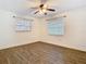 This bedroom has wood-look flooring, a ceiling fan, two windows and white walls at 148 Tarrytown Trl, Longwood, FL 32750