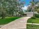 Charming home featuring a well-manicured lawn, mature trees, and a circular driveway at 148 Tarrytown Trl, Longwood, FL 32750