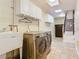 Laundry room has tile floors, washer, dryer, sink, cabinets and a refrigerator at 148 Tarrytown Trl, Longwood, FL 32750