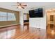 Open living room with hardwood floors, fan, and large window for natural light at 148 Tarrytown Trl, Longwood, FL 32750