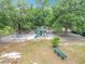 Playground with a swing set, slide, and picnic table set amongst large mature trees at 148 Tarrytown Trl, Longwood, FL 32750