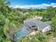 An aerial view shows a screened pool and the house with mature trees surrounding the property at 148 Tarrytown Trl, Longwood, FL 32750