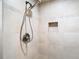 Tiled shower with a handheld shower head, decorative tile accent, and a built-in niche at 148 Tarrytown Trl, Longwood, FL 32750