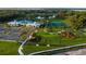 Aerial view of new construction community featuring a clubhouse, swimming pool, and a playground with manicured grounds at 1590 Contentment Loop, Kissimmee, FL 34744
