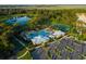 Aerial shot of community amenities with a pool, clubhouse, parking, tennis court, and a scenic view of the surrounding landscape at 1590 Contentment Loop, Kissimmee, FL 34744