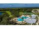 Aerial view of the community pool, clubhouse, and tennis court with scenic wooded backdrop at 1590 Contentment Loop, Kissimmee, FL 34744