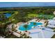 Aerial view of community pool, tennis courts, and surrounding landscape at 1590 Contentment Loop, Kissimmee, FL 34744
