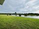 A serene view of the lake from the backyard, complete with lush greenery and a tranquil atmosphere at 1590 Contentment Loop, Kissimmee, FL 34744