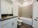This bathroom has gray tiled walls over the bathtub, white cabinets, and a dark stone countertop at 1590 Contentment Loop, Kissimmee, FL 34744