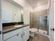 Modern bathroom featuring a shower with glass doors, gray tile, and a single vanity with a dark countertop at 1590 Contentment Loop, Kissimmee, FL 34744