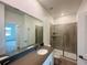 Modern bathroom featuring a shower with glass doors, gray tile, and an extended vanity with a dark countertop at 1590 Contentment Loop, Kissimmee, FL 34744