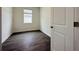 This bedroom has dark wood look floors and a window and a white door in the entrance at 1590 Contentment Loop, Kissimmee, FL 34744