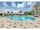Resort-style community pool featuring a slide, lounge chairs, and palm trees set against a blue sky with fluffy clouds at 1590 Contentment Loop, Kissimmee, FL 34744