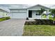 Charming single-story home with a brick driveway, well-maintained lawn, and a one car garage at 1590 Contentment Loop, Kissimmee, FL 34744
