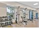 Well-equipped gym with weights, weight machines, and large windows offering natural light and outside views at 1590 Contentment Loop, Kissimmee, FL 34744