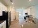 Well-equipped kitchen with stainless steel appliances, white cabinets, and a view of the laundry room at 1590 Contentment Loop, Kissimmee, FL 34744