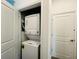 This laundry closet has a stacked washer and dryer next to a closed door at 1590 Contentment Loop, Kissimmee, FL 34744