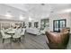 Open-concept lounge featuring stylish seating, wood-look tile, and a kitchen area with bar seating in the background at 1590 Contentment Loop, Kissimmee, FL 34744