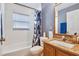 Full bathroom featuring a tub with a shower, granite vanity, and modern fixtures at 1621 Sunny St, Kissimmee, FL 34741