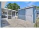 View of the side exterior of the home, featuring a screen-enclosed patio, concrete floor and white doors at 1621 Sunny St, Kissimmee, FL 34741
