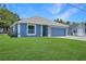 Charming single-story home featuring blue siding, a well-manicured lawn, and an attached two-car garage at 1621 Sunny St, Kissimmee, FL 34741