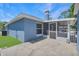 Exterior view with screened patio and concrete patio of the home, showcasing blue siding at 1621 Sunny St, Kissimmee, FL 34741