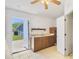 Kitchenette featuring tiled floors, cabinets, stainless steel sink, fridge, shelf, and an exterior door at 1621 Sunny St, Kissimmee, FL 34741