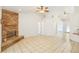 Bright living room featuring a stone fireplace, neutral walls, high ceilings with fans, and easy access to other areas at 1621 Sunny St, Kissimmee, FL 34741