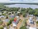 An aerial view captures a charming neighborhood and lake with homes nestled among trees, near lake access at 1840 Lillian Dr, St Cloud, FL 34771