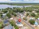 An aerial view captures a charming neighborhood and lake with homes nestled among trees, near lake access at 1840 Lillian Dr, St Cloud, FL 34771