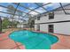 A screened-in pool is located next to a white two-story house providing a refreshing escape on warm days at 1840 Lillian Dr, St Cloud, FL 34771
