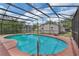 The screened-in pool with blue water and a red deck looks inviting with a set of stairs at 1840 Lillian Dr, St Cloud, FL 34771