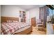 Bedroom with wood floors, a bed with a patterned comforter and a wooden dresser at 18851 Rawson St, Orlando, FL 32827