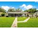 Spacious backyard showcasing a brick pathway leading to a garden arbor and a covered patio at 2095 Curry Ln, Orlando, FL 32812